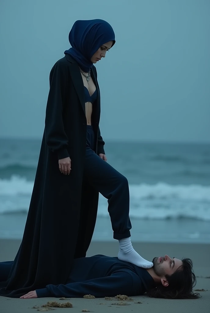 Navy blue headscarf on the beach, Black long coat, white socks, Sexy skinny woman. Man lying in front of woman. Woman puts her foot on the front of man&#39;s sweatpants. 