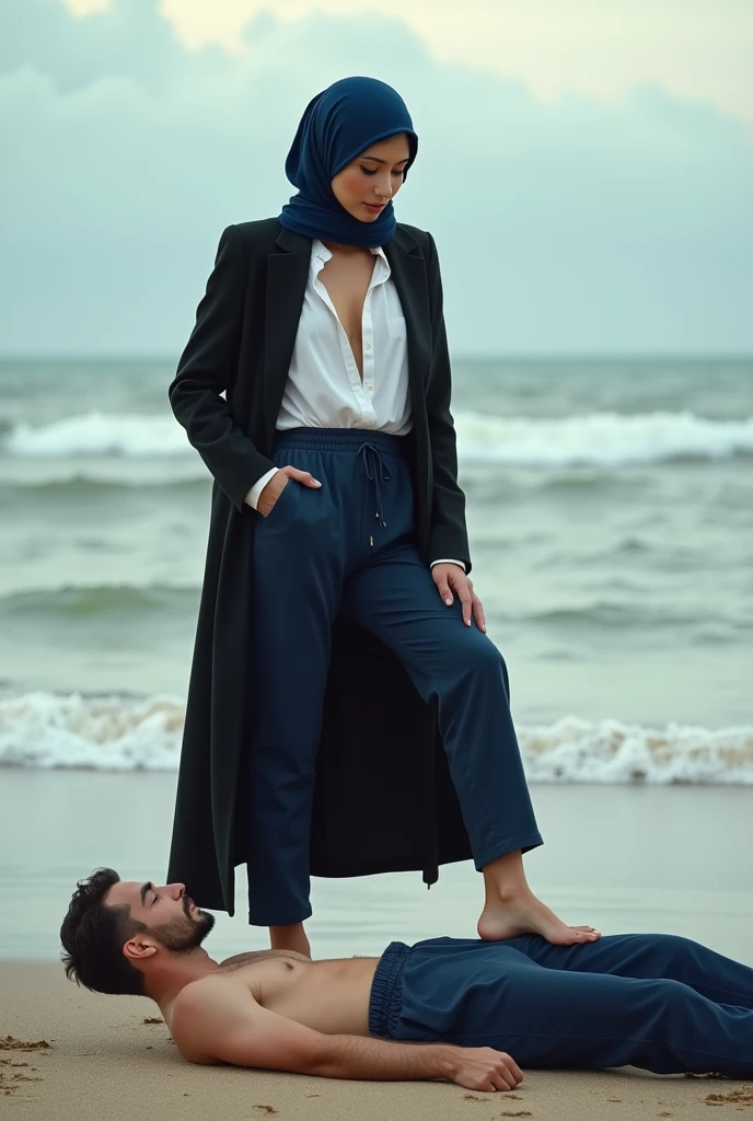 Navy blue headscarf on the beach, Black long coat, barelegged, white shirt,  skinny woman. Man lying in front of woman. Woman puts her foot on the front of man&#39;s sweatpants. 