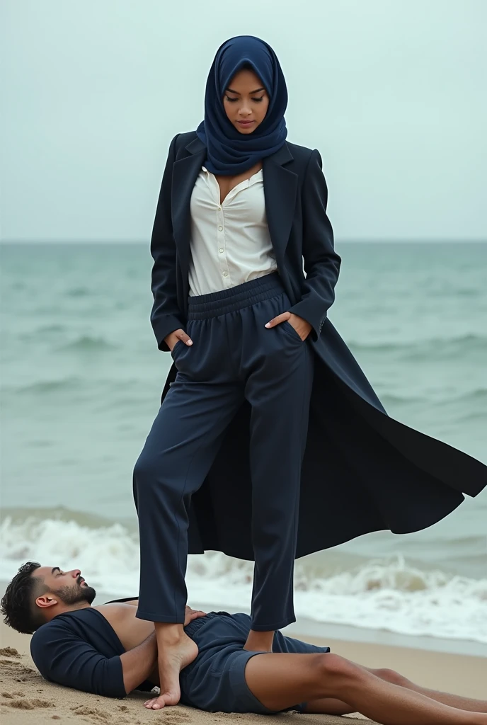 Navy blue headscarf on the beach, Black long coat, barelegged, white shirt, skinny woman. Man lying in front of woman. Woman puts her foot on the front of man's sweatpants.