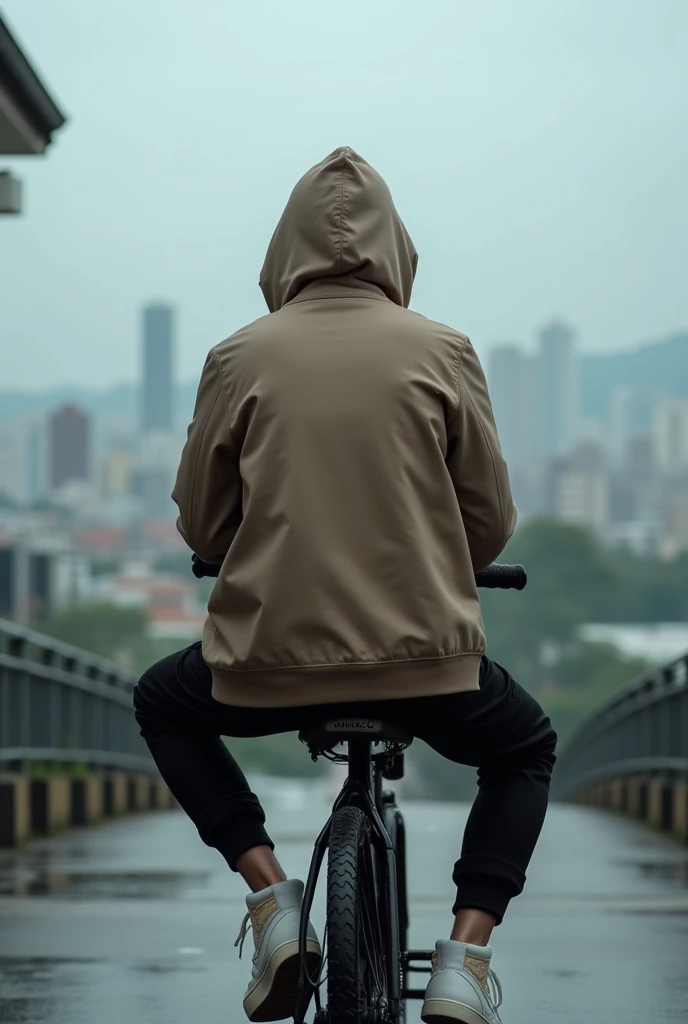 A realistic photo of a hooded boy in a light chocolate coat, and a black sweatpants with white high-top sneakers, Nike style but they are not totally Nike.  Sitting looking at Panama City from Amador. The photo taken from behind of the person sitting on a bicycle . The weather is cloudy or rainy. Hooded so that nothing can be seen of his head