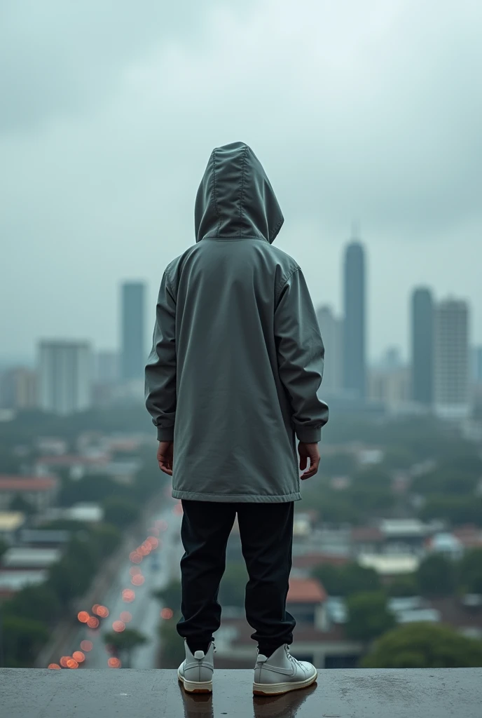 A realistic photo of a tall hooded boy in a grey Nike coat, and a black sweatpants with white high-top sneakers, Nike style but they are not totally Nike. looking at Panama City from the tallest tower in Old Panama The photo taken from behind the person. The weather is cloudy or rainy. Hooded so that nothing can be seen of his head