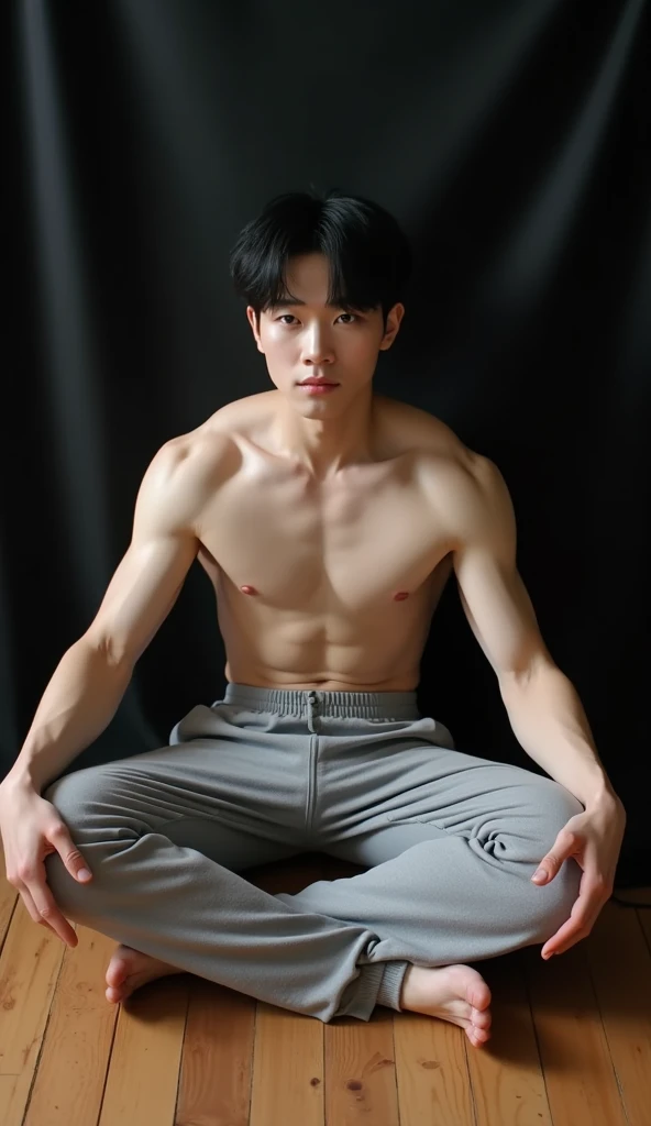 From upper camera angle ,hands are behind body taking support from hands , wide open hands on floor . 
Hyper realistic, Arafed 25 Korean  man, white skin, muscular body, sitting on wooden floor of living room with black cloth background. Legs are wide open in a cross legs with big dick highlighted from full gray gym pants.  hands are also wide open taking support from floor , black eyes. 