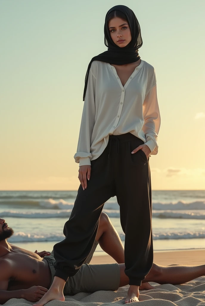 Black headscarf on the beach,black sweatpants,barefoot sexy skinny woman in white long sleeve t-shirt. Man lying in front of woman. Woman puts her foot on the front of man's sweatpants.