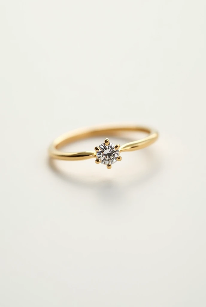 Classic gold engagement ring with a small diamond on a white background