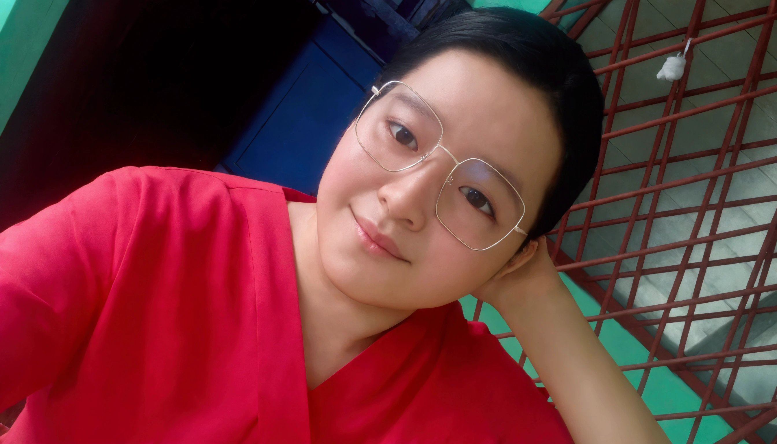 Create a photorealistic image. A picture of a pretty 30 year old Malaysian woman on a cruise ship. She is lying on her back on a deck chair. She has long hair and is wearing glasses. She is lying on her back in a deck chair on a cruise ship. She is holding a drink and looking at the camera and smiling. She is wearing a red t-shirt and white shorts. You can see her whole body from her head to her feet.