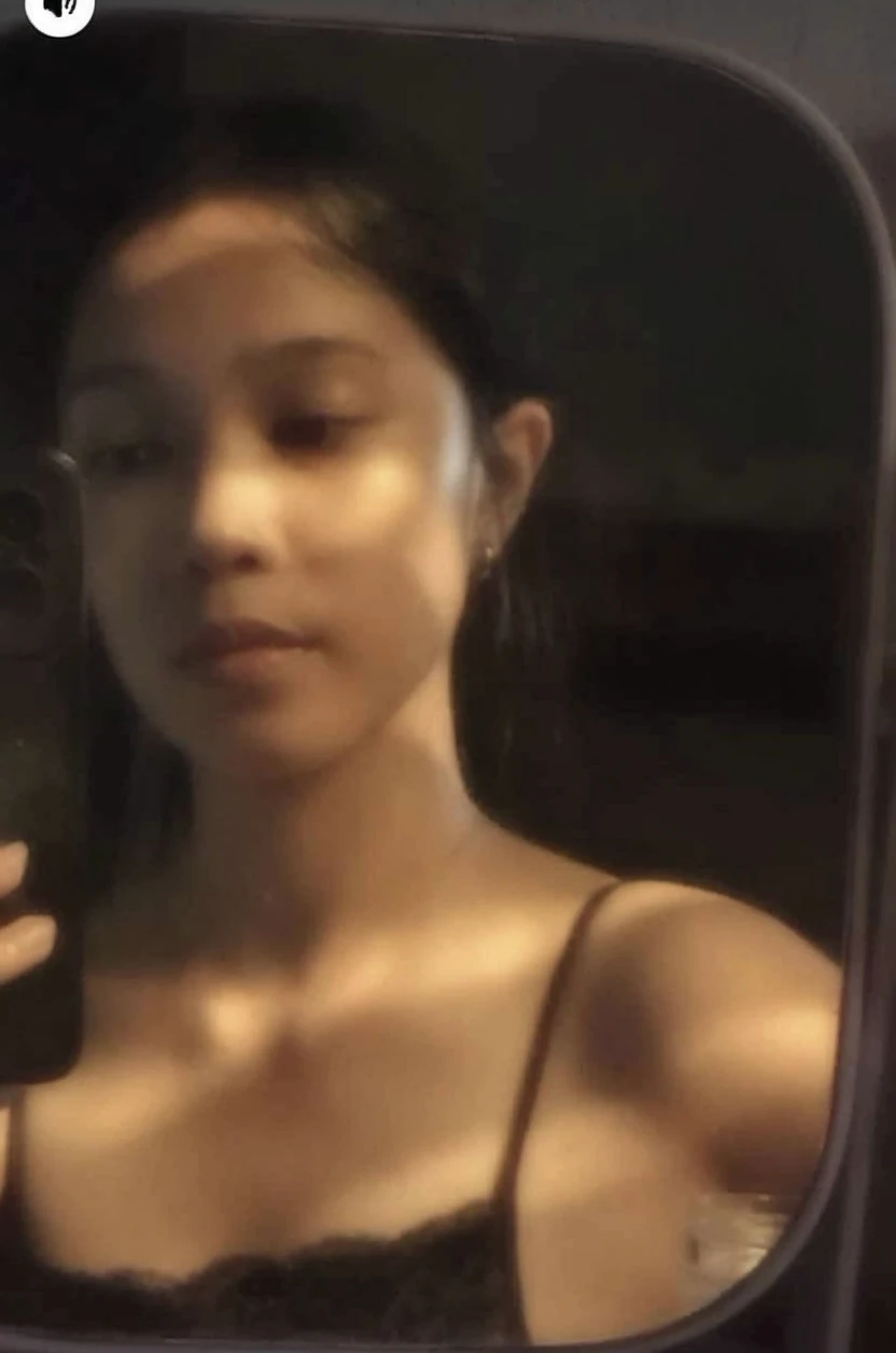 (Photorealism:1.5)indian girl,brown body,average body proportion,girl taking selfie in mirror through phone,mirror selfie,iphone 15,phone hides face and eyes,long straight hair,topless body,small breasts,long hair hides nipples,standing pose,front facing shot,front body,standing nervously,whole background covered by black wardrobe,black wardrobe without any design,sides of mirror not visible,loose white panty,legs crossed,lights out in room,dark room,body lit by moonlight,face hidden by phone,semi-folded maroon tshirt on one hand