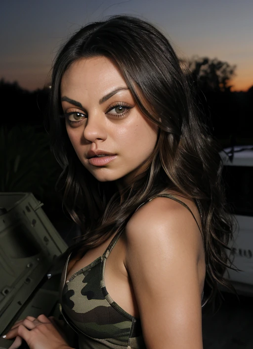 Mila Kunis in camouflage pixel, stands on the back of a pickup truck and shoots a machine gun into the night sky 