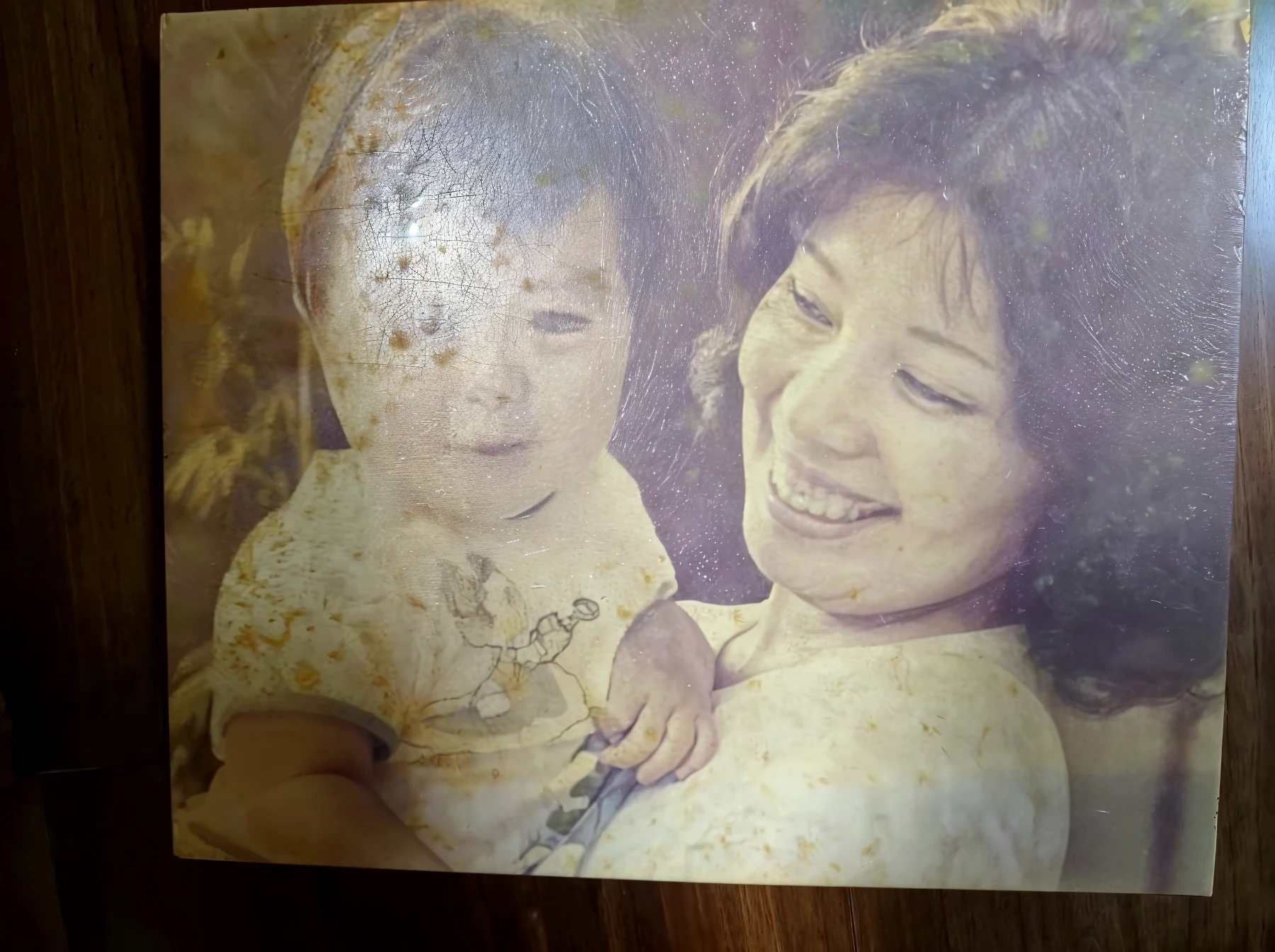 There was a woman holding a child,Fujifilm color flash,1200 DPI scan,Taken in the late 1980s,80s photo,1980s photo,Fuji photo from the 1980s,About 35 years old,1990's photo。
