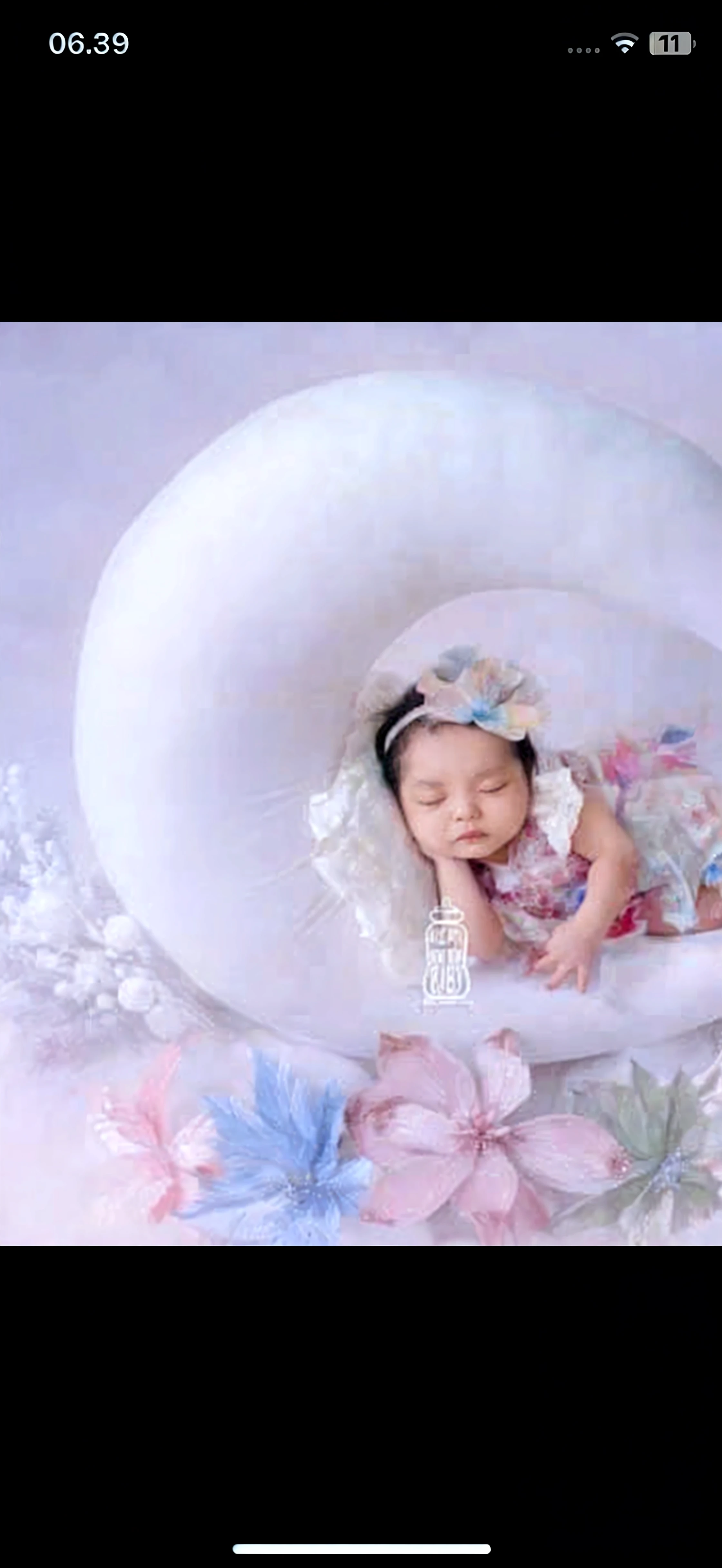 A highly detailed ultra realistic photography of filipino newborn baby girl, dressed by white angel gown, the baby is lying on the feather newborn baby mat. The photo is like a photo shoot drone shot.