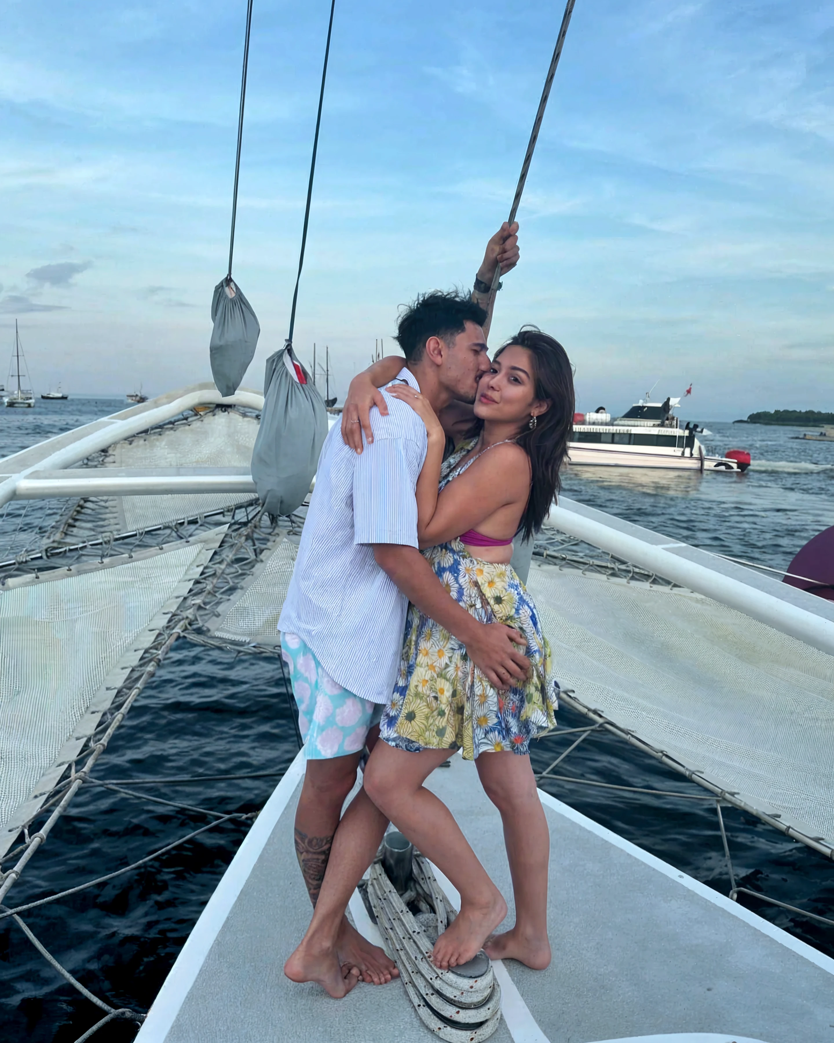 There's a man and a woman kissing on a boat at sunset, beijando juntos fofos, em um barco, casal se beijando, Tyler Edlin e Natasha Tan, beijos juntos, during sunset, Postagem no Reddit, Jordan Grimmer e Natasha Tan, beijando-se, Fotografia tirada em 2 0 2 0, beijo lindo, Beijar, they are in love, with sunset, instagram post