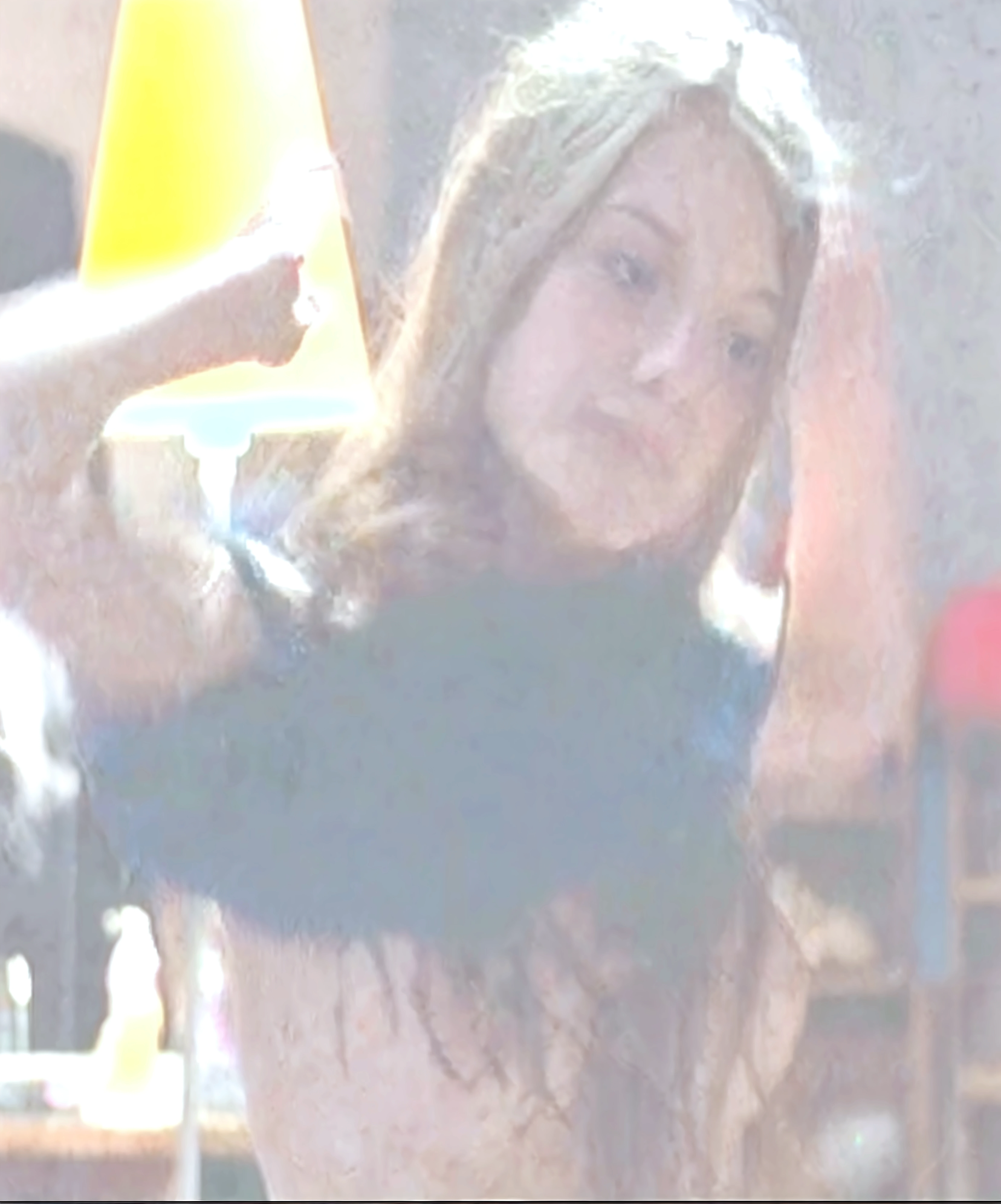 Create a photo of a 30 year old young woman, with a slender and beautiful body, with bare breasts and wearing black sweatpants, with white and clear skin, with long light brown hair, in fear as her arms are pulled behind her back by a teenage boy and her pants are being pulled down to her knees by two nervous black teenage girls, ugly, thin, small, dark black skinned, who wears glasses and a blue dress.