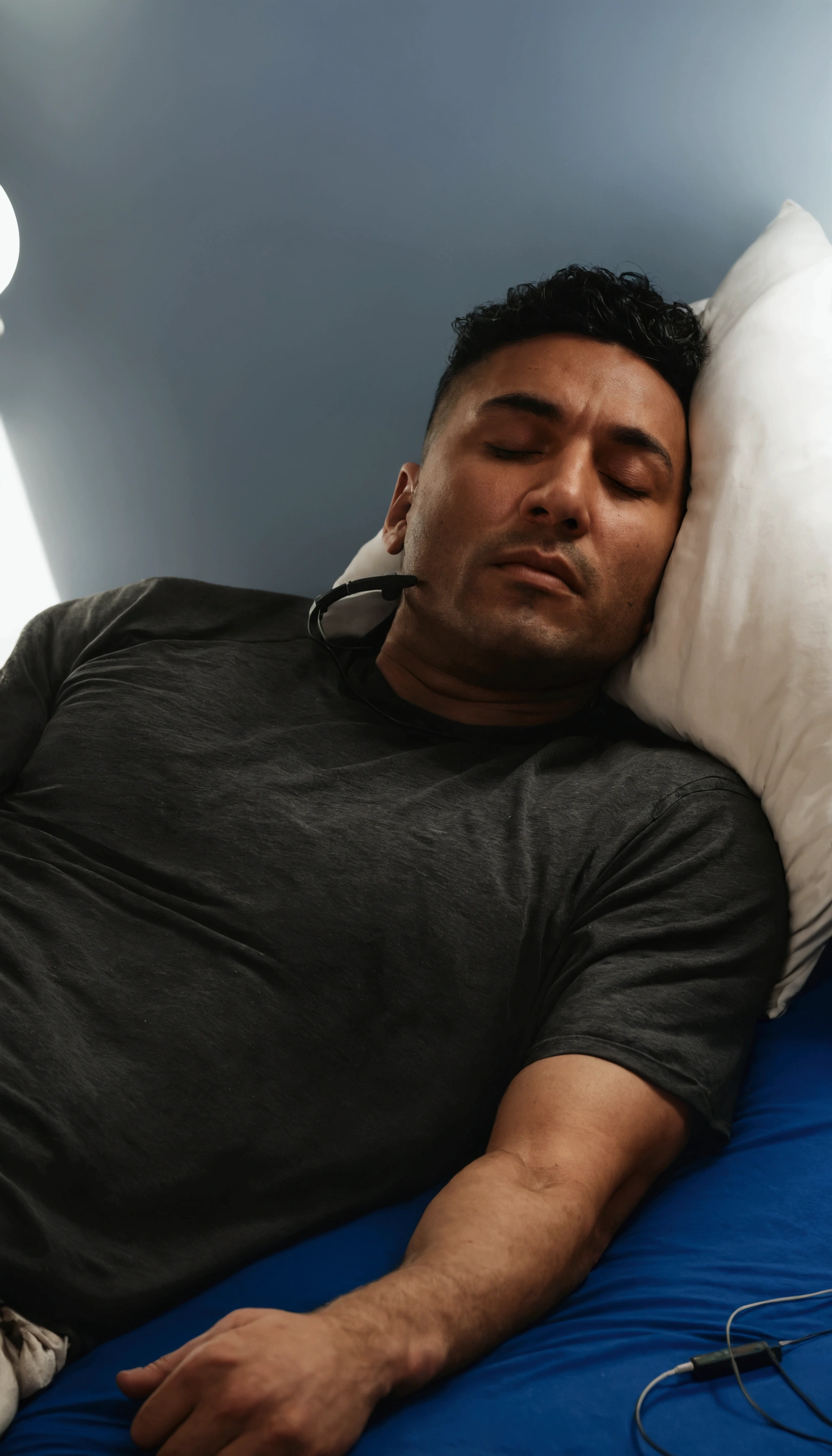 A 30 year old Indonesian man, slightly fat, wearing shorts, is sleeping casually on a bed with a beautiful Indonesian woman wearing a bikini, with a minimalist bedroom in the background.
