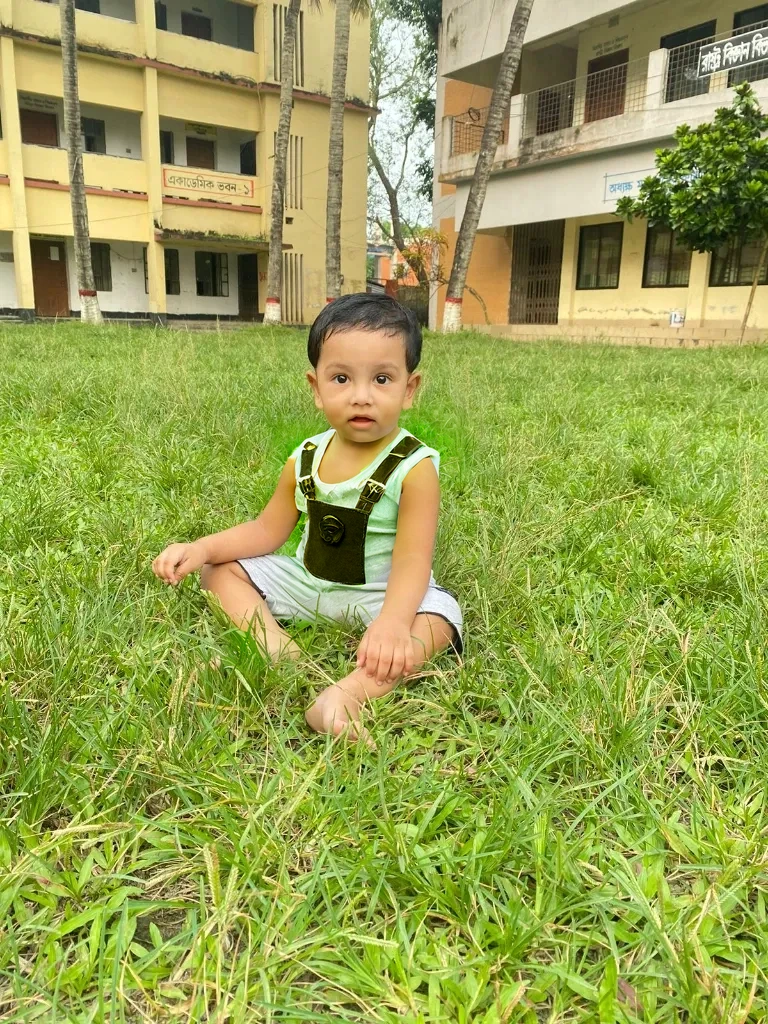 Retrato realista de um menino de sete anos, Ele usa uma camisa vermelha . Your face is and exploratory . Ele sai cautelosamente para o jardim da casa,  A small cat is among the bushes and he touches it cautiously ,Not facing the camera,, Hair is messy , 