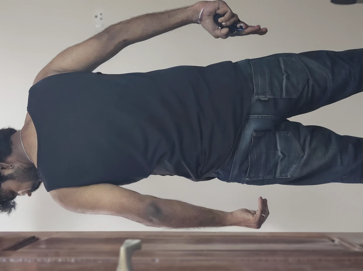 Create a realistic photo of a person clinging to the ceiling with their hands and feet. 