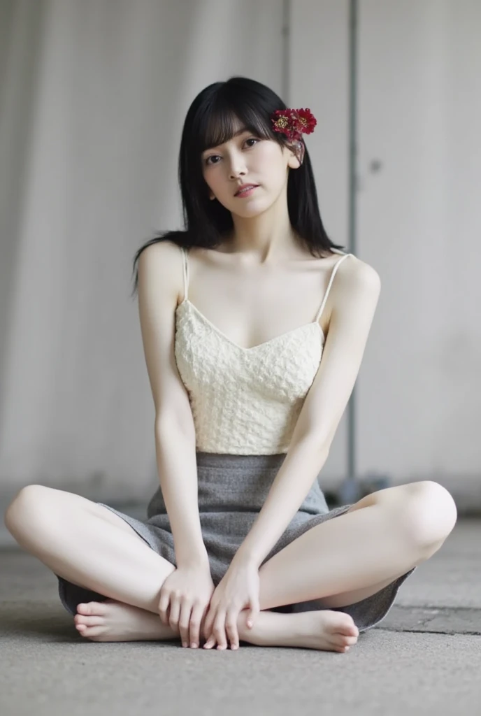 She is wearing a camisole and posing cross-legged while smiling and winking、The background is a monotone 、
