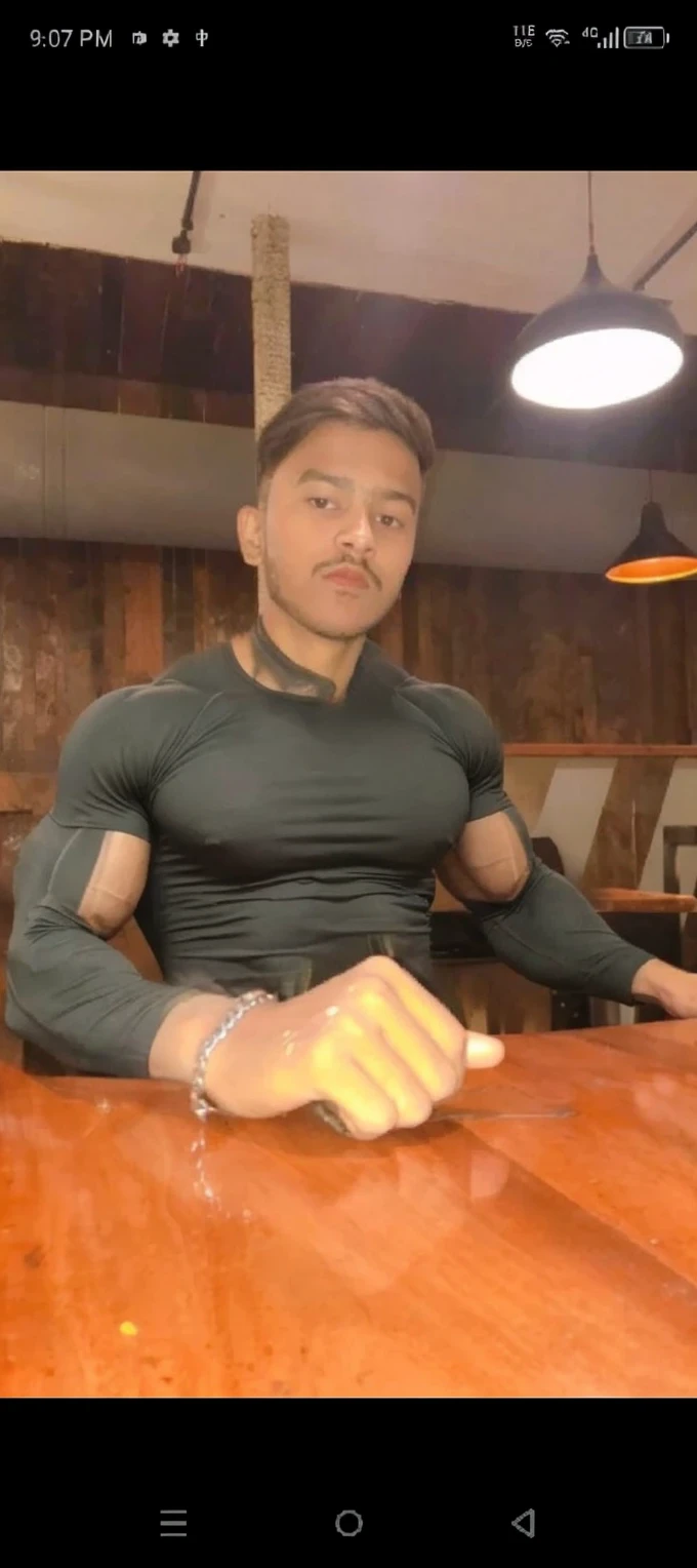 Character named "Nobita" , masculine, muscle, alt boy look, e-boy look, grunge, black sleeveless top, silver chains, silver bracelets, selfie in front of mirror pose, textured french crop hairstyle, silver spectacles, thin trimmed mustache