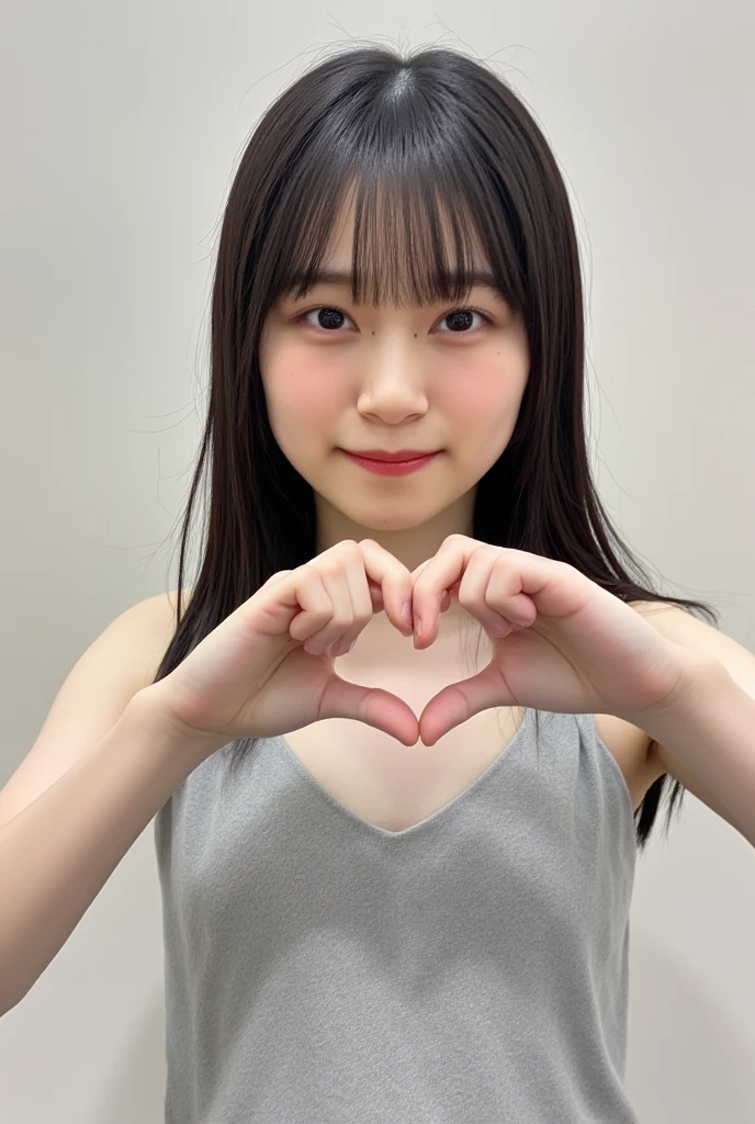 Only one smiling woman poses wearing a camisole, making a firm big heart shape with both hands, and holding it in front of her chest, View above collarbone、The background is a monotone 、
