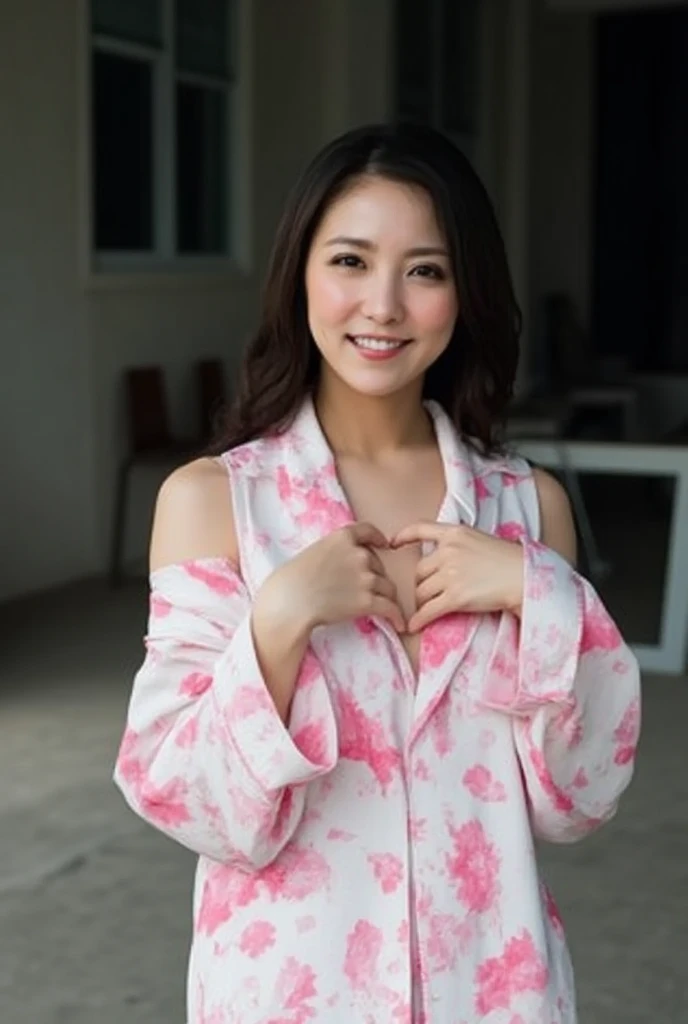 A smiling woman is posing alone wearing off-the-shoulder pajamas, making a firm big heart shape with both hands, and holding them in front of her chest, View above collarbone、The background is a monotone 、
