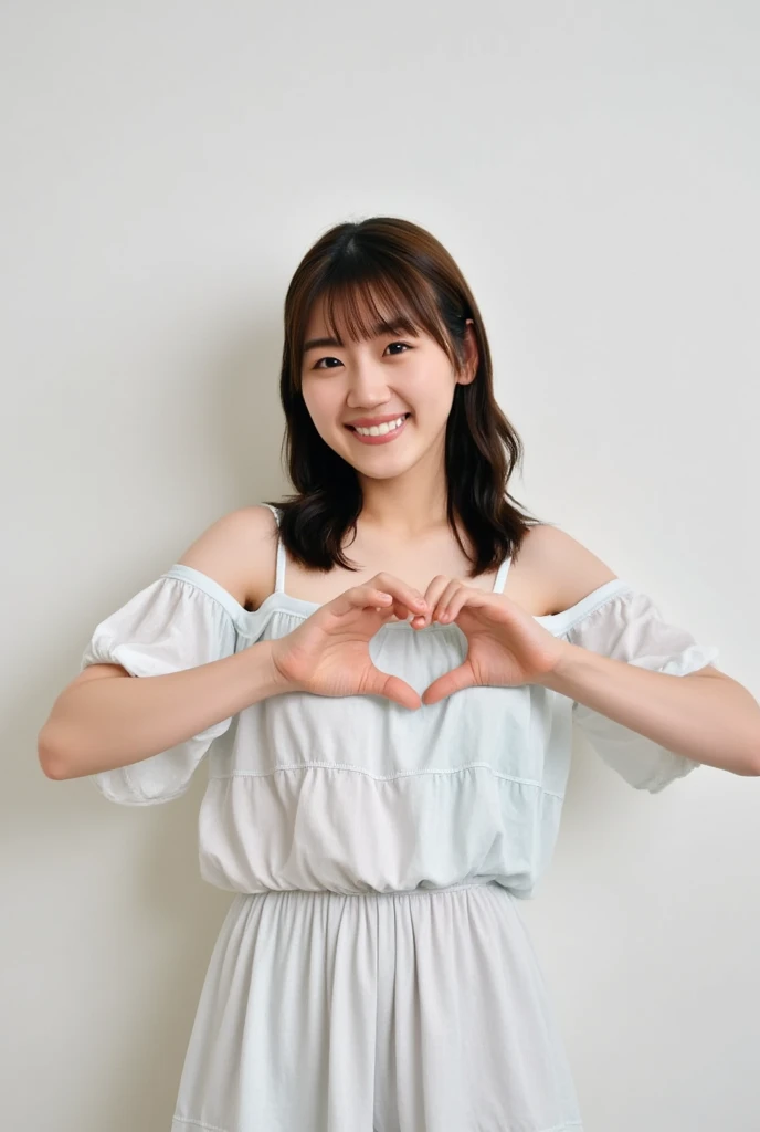 A smiling woman poses alone wearing off-the-shoulder pajamas in pastel colors that convey warmth simply by touching them softly and softly, making a firm, large heart shape with both hands, and holding them in front of her chest, View above collarbone、The background is a monotone 、
