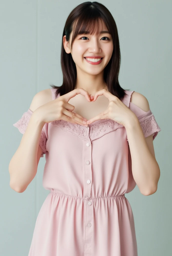 A smiling woman poses alone wearing off-the-shoulder pajamas in pastel colors that convey warmth simply by touching them softly and softly, making a firm, large heart shape with both hands, and holding them in front of her chest, View above collarbone、The background is a monotone 、
