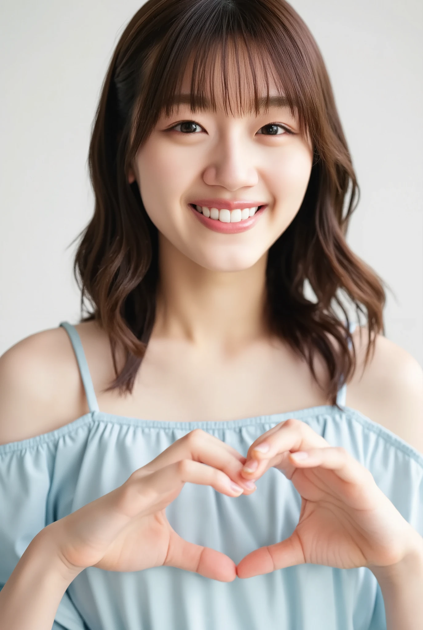 A smiling woman poses alone wearing off-the-shoulder pajamas in pastel colors that convey warmth simply by touching them softly and softly, making a firm, large heart shape with both hands, and holding them in front of her chest, View above collarbone、The background is a monotone 、
