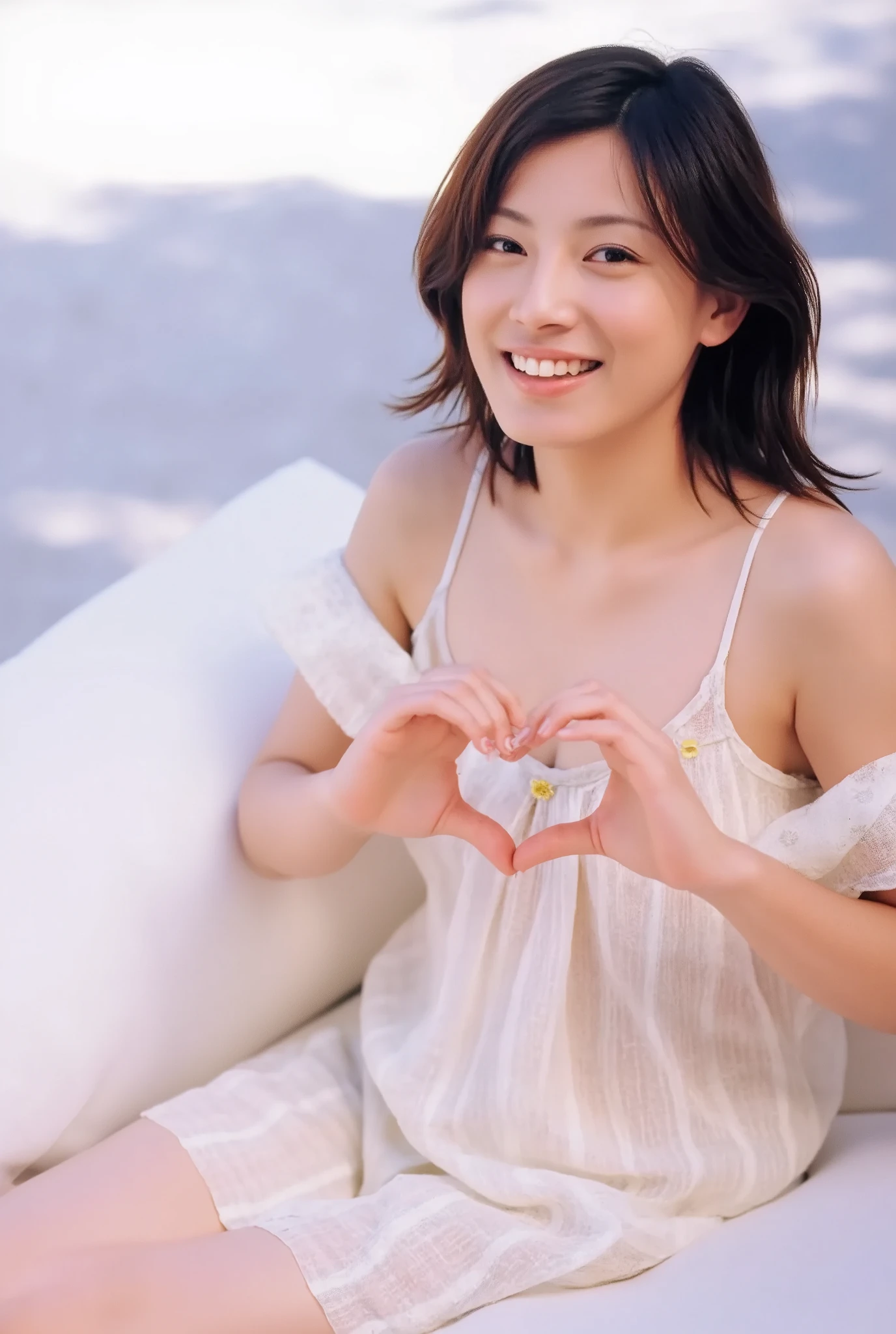 A smiling woman poses alone wearing off-the-shoulder pajamas in pastel colors that convey warmth simply by touching them softly and softly, making a firm, large heart shape with both hands, and holding them in front of her chest, View above collarbone、The background is a monotone 、
