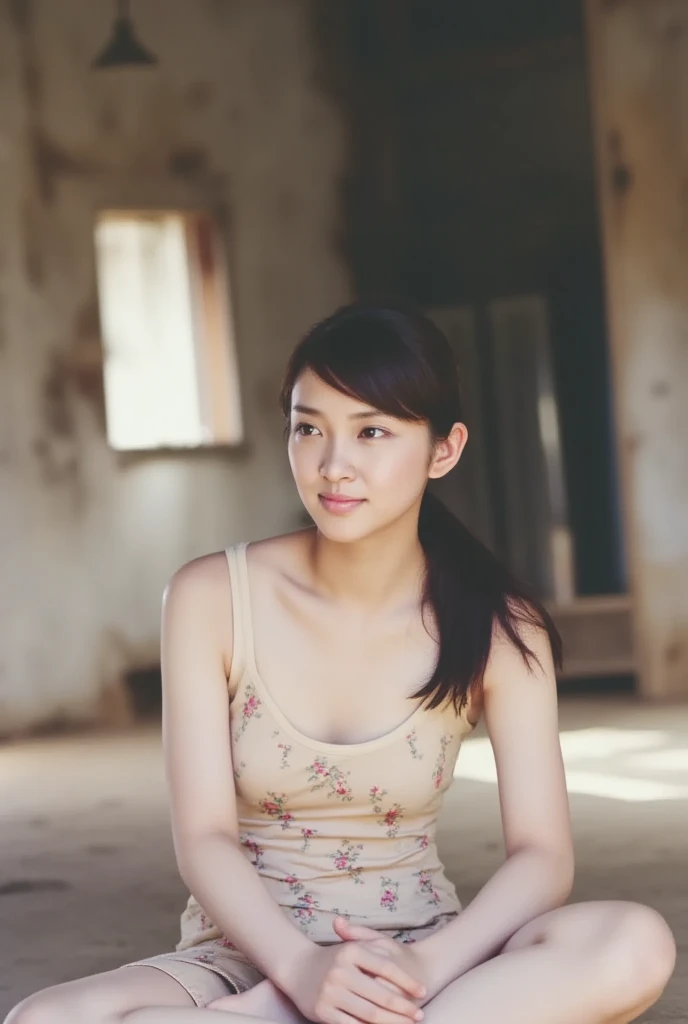 A smiling woman is alone in a cross-legged pose wearing a thin camisole, View above collarbone、The background is a monotone 、
