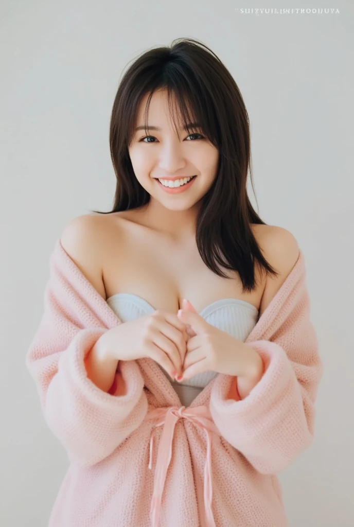 A smiling woman poses alone wearing off-the-shoulder pajamas in pastel colors that convey warmth simply by touching them softly and softly, making a firm, large heart shape with both hands, and holding them in front of her chest, View above collarbone、The background is a monotone 、
