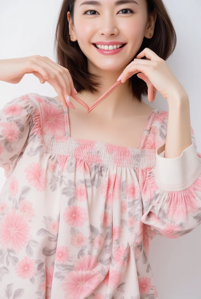 A smiling woman poses alone wearing off-the-shoulder pajamas in pastel colors that convey warmth simply by touching them softly and softly, making a firm, large heart shape with both hands, and holding them in front of her chest, View above collarbone、 background is monotone、
