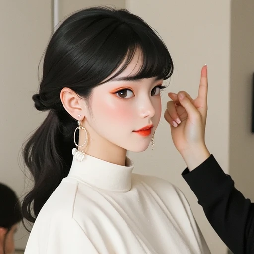 A Korean boy is like making a peace pose near his eye and smiling widely. He is being styled by a makeup artist. He is wearing a white barber's coat. Her long hair is being held back by a Hello Kitty clip. 

He has piercings in his lips. 