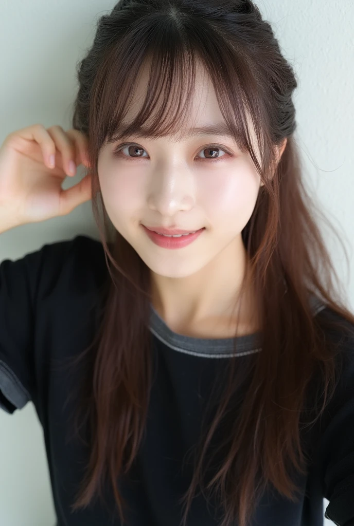 An overhead view of an Asian cute woman, with bangs and long, straight brown hair reaches all around her shoulders. She's head in two rows, her left side by a small amount of water on her face. Her eyebrows, their eyes are slightly turned to the side, with a few of them perched on their right ear. The woman's right arm is positioned in front of her face, her right hand resting on her left ear. She is smiling, her lips slightly lighter purple. She has a soft, smooth texture all she is holding in the air. She wears a black t-shirt with a dark-gray trim. The background behind her is a light white wall.