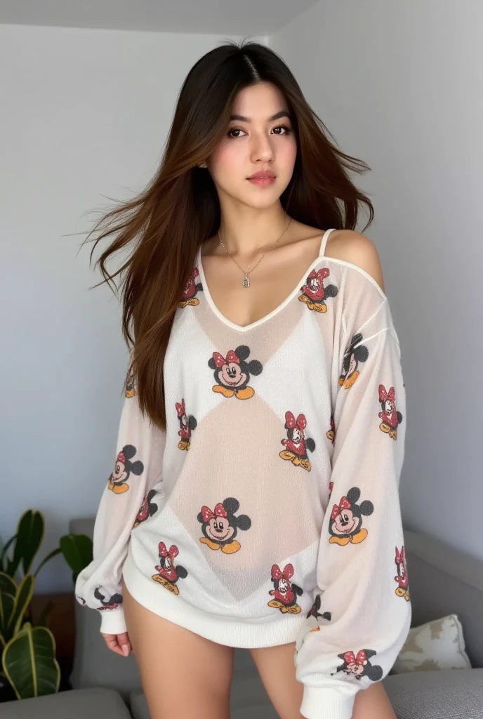 a young woman stands against a living room. She is dressed in a sheer oversize mini dress adorned with a pattern of micky mouse. Her hair is long brown adding a touch of movement to her face. The woman's dress is adorned in a batic patern. She stands tall