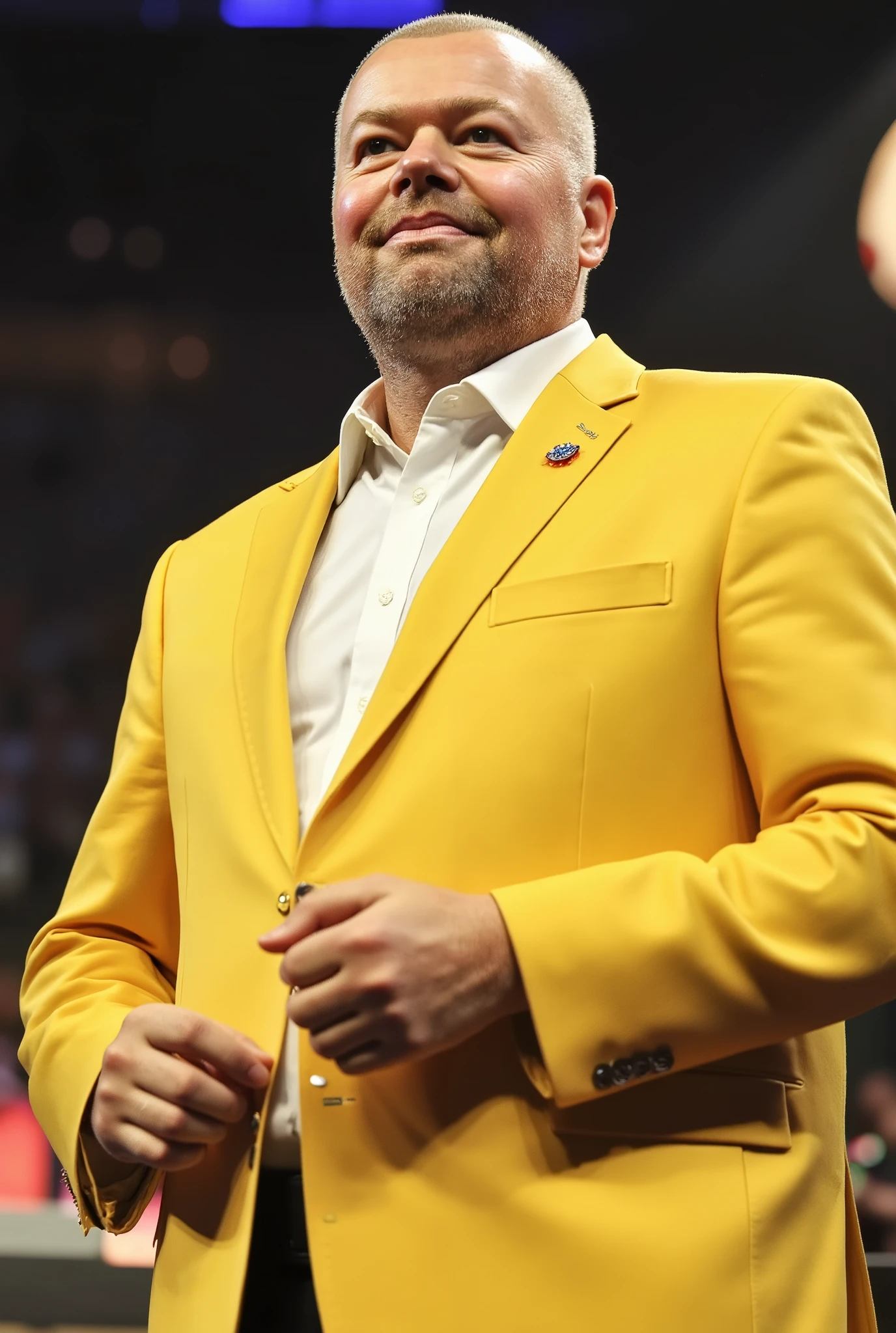 A high-resolution photograph of Raymond van Barneveld, wearing a vibrant yellow suit with a white dress shirt, standing in a dynamic pose.