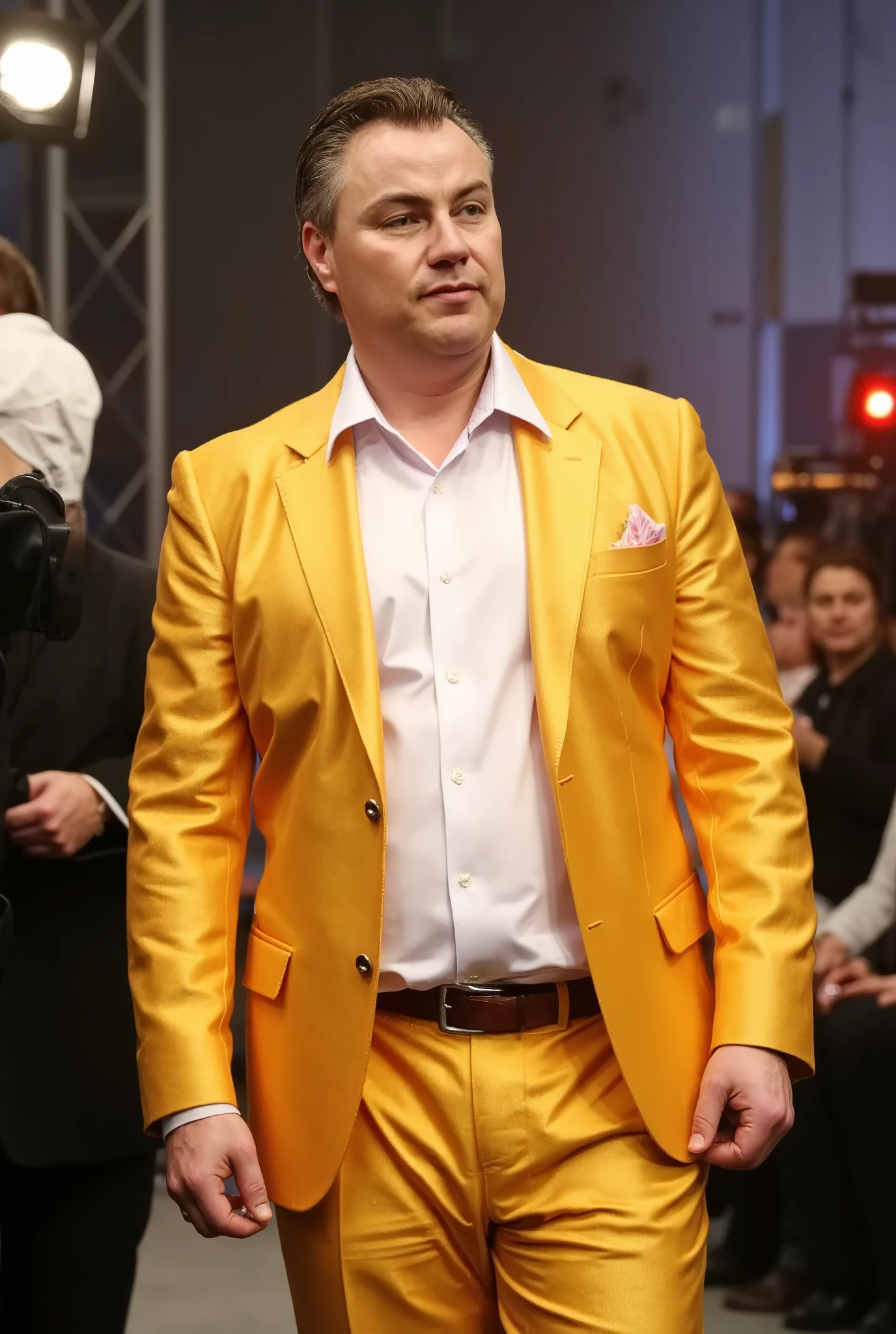 A high-resolution photograph of John Part, wearing a vibrant gold suit with a white dress shirt, standing in a dynamic pose.