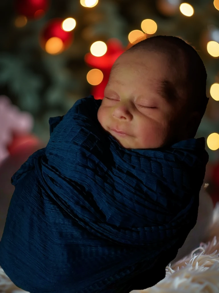 Baby boy lying on a blanket , in a blue suit, Christmas tree, Warm light lanterns, smooth red skin, New Year'window