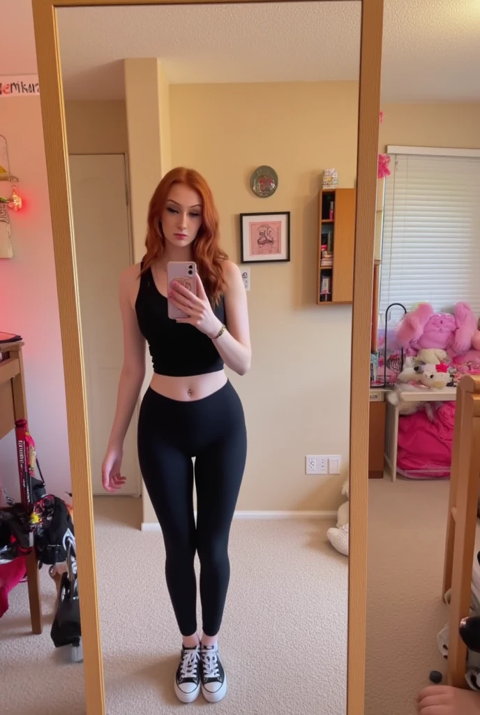 emmaleiah. The image is a photograph of a young woman taking a selfie in front of a full-length mirror in what appears to be a cozy, feminine bedroom. The woman, with long, curly red hair and fair skin, is wearing a black sleeveless top and black leggings, along with white sneakers with black accents. She is standing in a room with beige walls and a light-colored carpet.