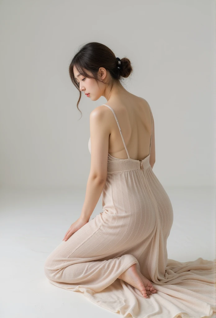 woman face down on her knees wearing a maxi knitted dress, rear view angle completely