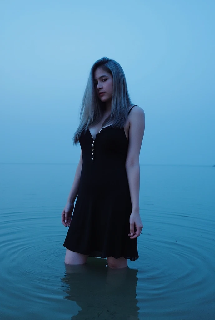 "A woman with long wavy hair wearing a black dress stands in shallow water during twilight. She gazes to the side with a calm and contemplative expression. The background features a calm lake or sea with gentle ripples and soft reflections of light on the water surface. The atmosphere is serene and peaceful, with cool blue tones dominating the scene."