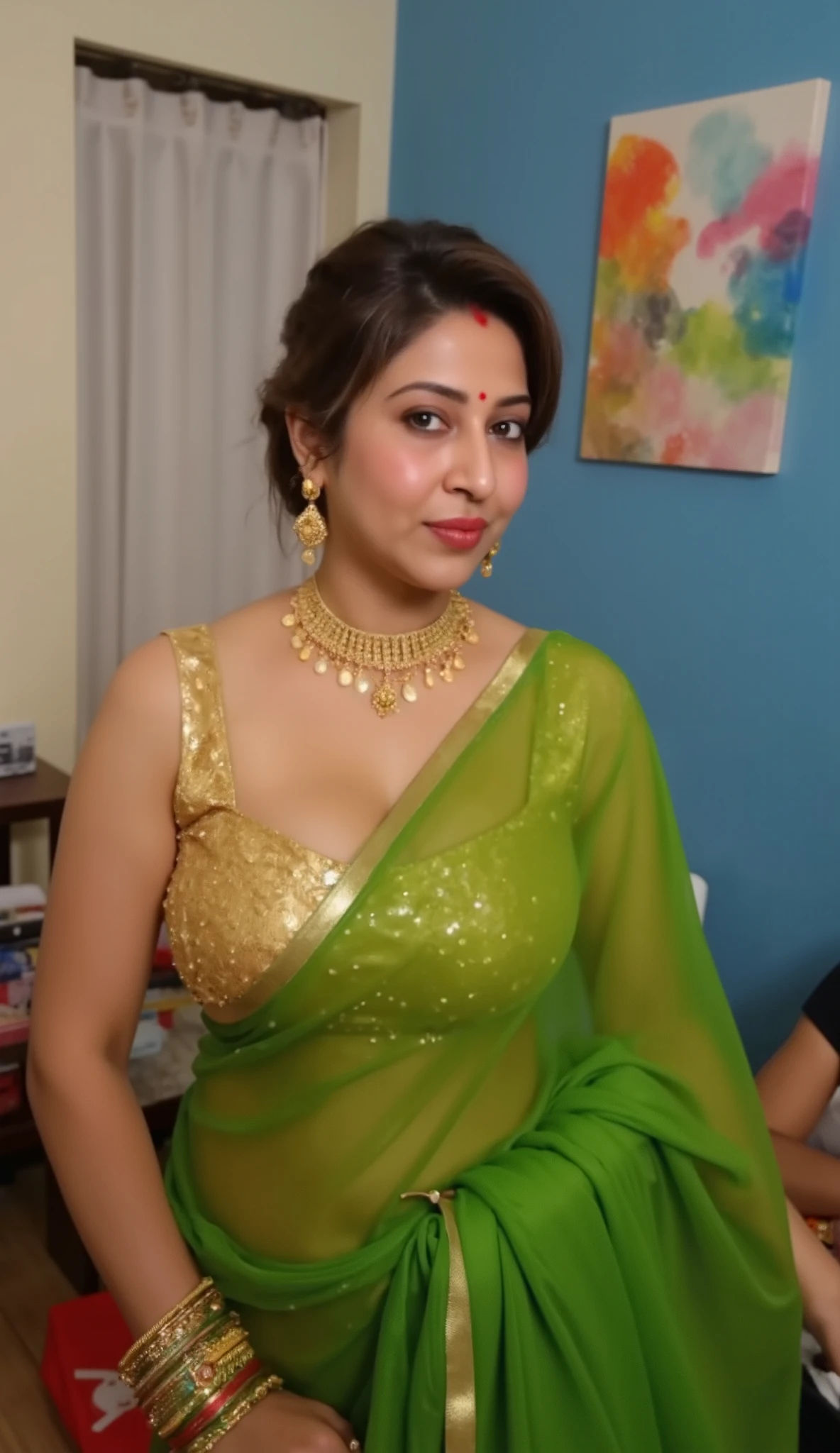 The image is a high-resolution photograph featuring an intimate, indoor scene. The subject is a middle-aged woman, likely of Indian descent, with a medium skin tone, and a well-defined facial structure. She is dressed in traditional Indian attire, wearing a golden shiny silk Sleevless Deep low neck blouse and a glossy reflective green transparent saree, Voluptuous-body,
Her hair is neatly pulled back into a low bun. She accessorizes with simple gold jewelry, including a gold necklace and matching earrings. Her expression is sexy and biting lips, seducing expression,side pose only, looking the viewer
The background reveals a domestic interior with white blue walls, a piece of furniture with a colorful abstract painting hanging on it, and a hint of other household objects, suggesting a warm and lived-in space. The lighting is soft, enhancing the emotional intensity of the moment captured.full length image,side view only,