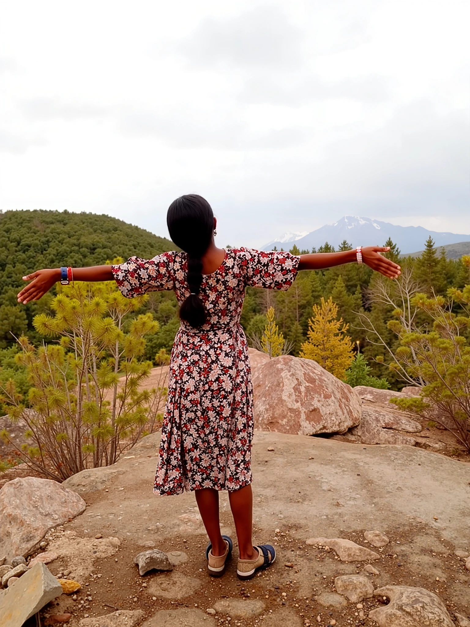 A young girl named Siya playing beneath a tree on a mountain with the sunset in the background.
