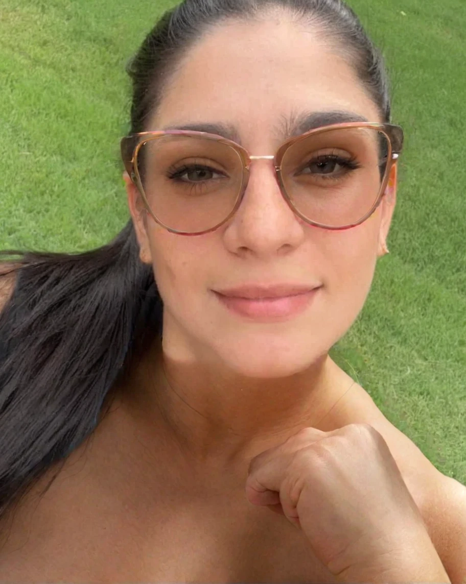 a naked woman with glasses is smiling for the camera with a picture of a tree in the background, inspired by Verónica Ruiz de Velasco, headshot profile picture, around 30 yo, curly, colombian, professional profile picture, with glasses, vacation photo, instagram story, nivanh chanthara, riyahd cassiem, portait photo profile picture, profile pic