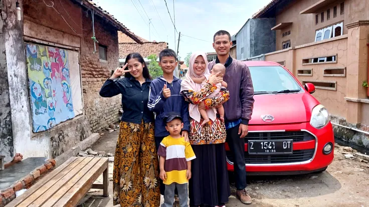 there is a man and woman holding a in a street, an indonesian family portrait, happy family, shot on sony a 7 iii, shot on nikon z9, shot on leica sl2, full protrait, 60mm portrait, shot on canon eos r 5, shot on canon eos r5, shot on sony a 7, family, portrait shot
