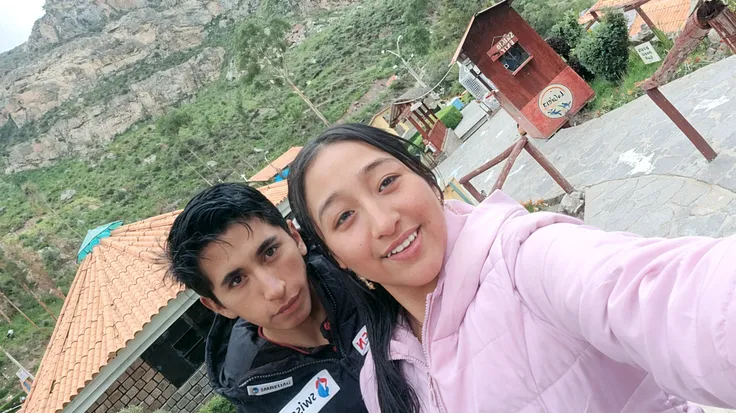 They are posing for a photo in front of a fence., pareja, parque en el fondo, with mountains in the background, intentalo, lovely pareja, con un parque al fondo, castigo, selfie enamorado, foto de vacaciones, 8k foto autofotograph, with mountains in the background, foto autofoto, Foto, mexicano, en un parque, imagen de perfil