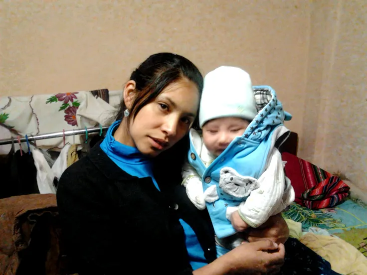make a illustration with atypical mother, holding a baby on her lap, neurodivergent baby, baby with autism, wearing clothes with the colors of the autism symbol, yellow, red, light blue, and dark blue, in a puzzle.