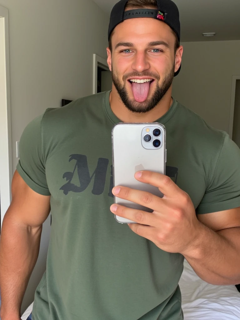 ericjanicki a man taking a selfie. he is handsome. he is muscular. he is a bodybuilder. he is wearing a green t-shirt. he is wearing a black backwards cap.  he is looking foward. he is looking straight ahead. he is smiling. he is sticking his tongue out of his mouth. he is in a bedroom. it is daytime.