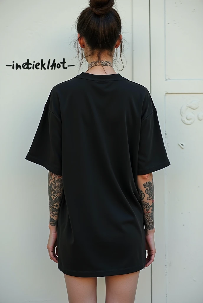  A woman standing with her back to the camera ,  wore an oversized black T-shirt that accentuated the impression simple yet stylish .  She combines them with hotpants ,  creating a casual and modern look .  The back of the plain t-shirt shows a relaxed yet characterful silhouette of the body .  An artistic tattoo adorns her right arm ,  covered skin with details that accentuated personal expression .  Another tattoo is visible on her neck ,  adding a bold and alluring touch .  Against the background of a simple white wall but stands out because of the inscription "INDIEKLHOT ,"  fully focused on a mix of clothing styles ,  body art ,  and an implied message of inclusion .  This blend reflects a free personality , Self-confidence,  and full of meaning .