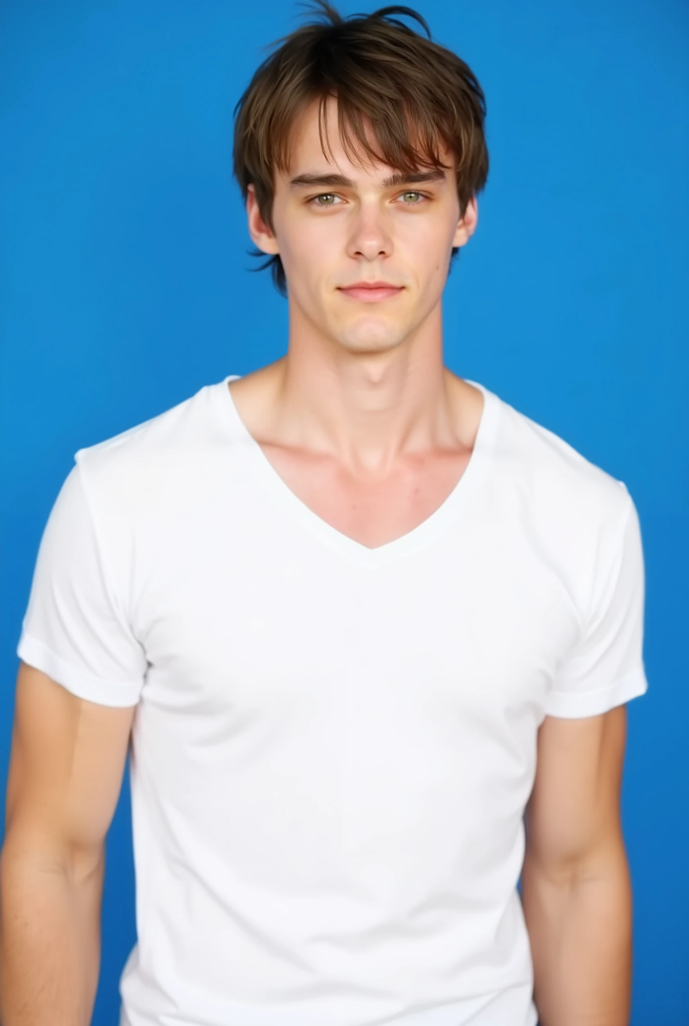 Mitchell Hope. The upper body image is a high-resolution photograph of Mitchell Hope standing against a solid blue background. He has a fit, athletic build with well-defined muscles. He has a light complexion and messy, tousled brown hair. He is dressed fitted plain white t-shirt that fits him snugly, highlighting his toned arms and chest.