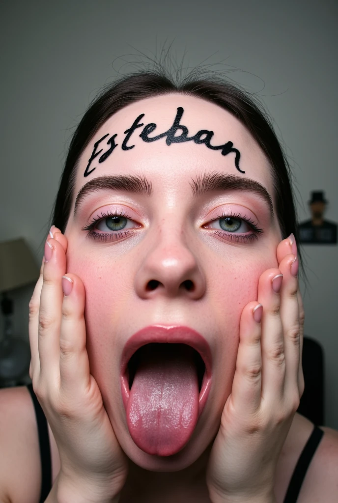 Billie Eillish opening her mouth wide showing the inside while stretching her cheeks with her hands, en su frente tiene escrito el nombre ESTEBAN