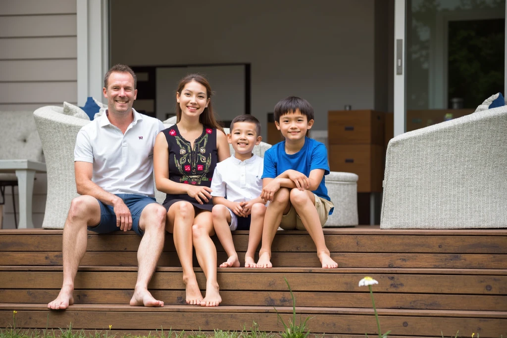 High standard house, with a family hugging each other and a very happy real estate agent on the side.