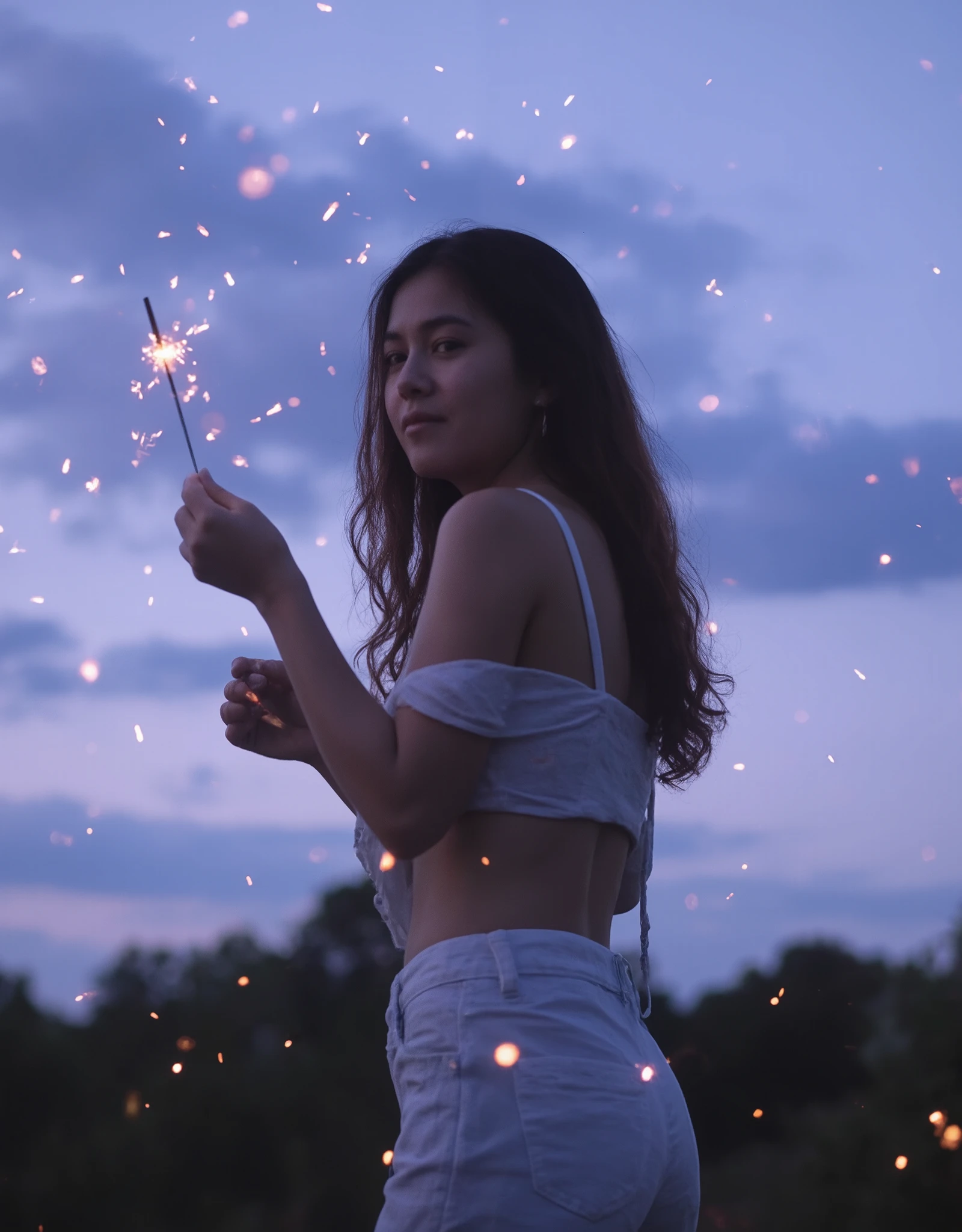 Professional photographic shot of a young woman in casual summer attire — a light, flowy blouse and denim shorts. She holds a lit sparkler in her hand, tiny golden sparks flying, creating glowing points of light. Her long, wavy hair moves freely, partially covering her face as she turns slightly away from the camera. The scene is set outdoors at dusk, with a dreamy sky blending soft shades of blue and purple, scattered clouds adding subtle texture. The atmosphere is light and carefree, capturing the magic of a summer evening. Natural and gentle lighting bathes the image, the warm sparkler glow contrasting against the cool twilight hues. The shot is taken from a low angle, looking upwards, emphasizing the dynamic motion of the girl. Some areas of the image are intentionally blurred, adding a sense of movement, while a shallow depth of field draws focus to the girl and the shimmering sparks. Soft bokeh effects dance in the background, and delicate shadows highlight the nostalgic and magical vibe of the moment.